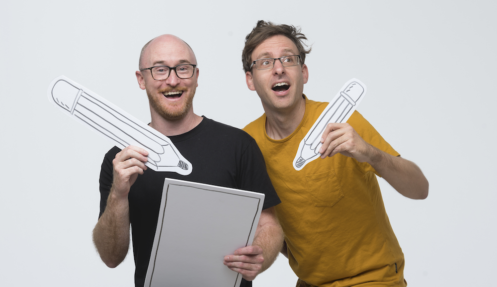 A photograph of Ben Wood and Andrew McDonald holding fake pencils